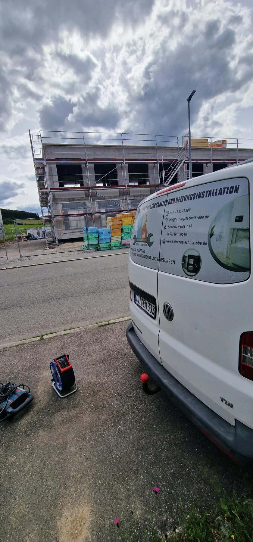 Unser Firmenfahrzeug mit SBE-Beschriftung vor dem Rohbau